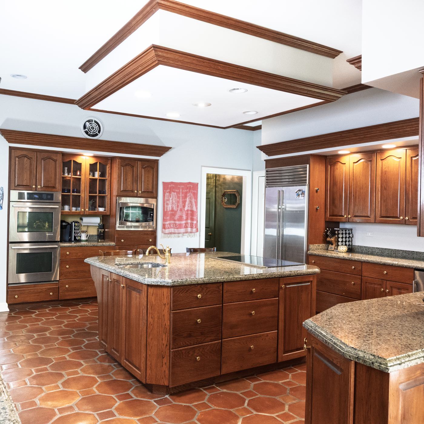 The gourmet kitchen with terracotta tile and a granite island